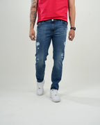 Jeans azul medio con efecto desgastado y rasgados decorativos