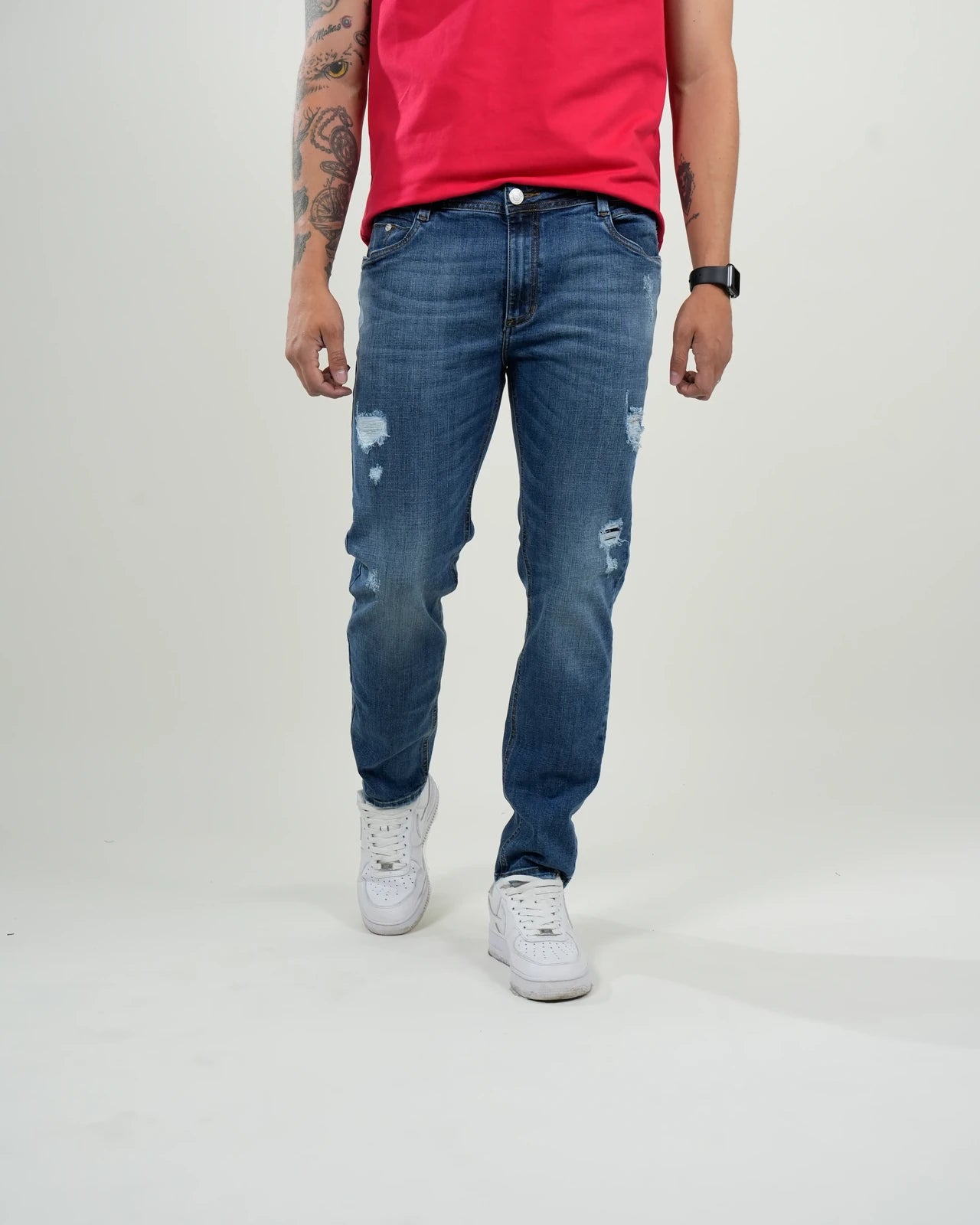 Jeans azul medio con efecto desgastado y rasgados decorativos