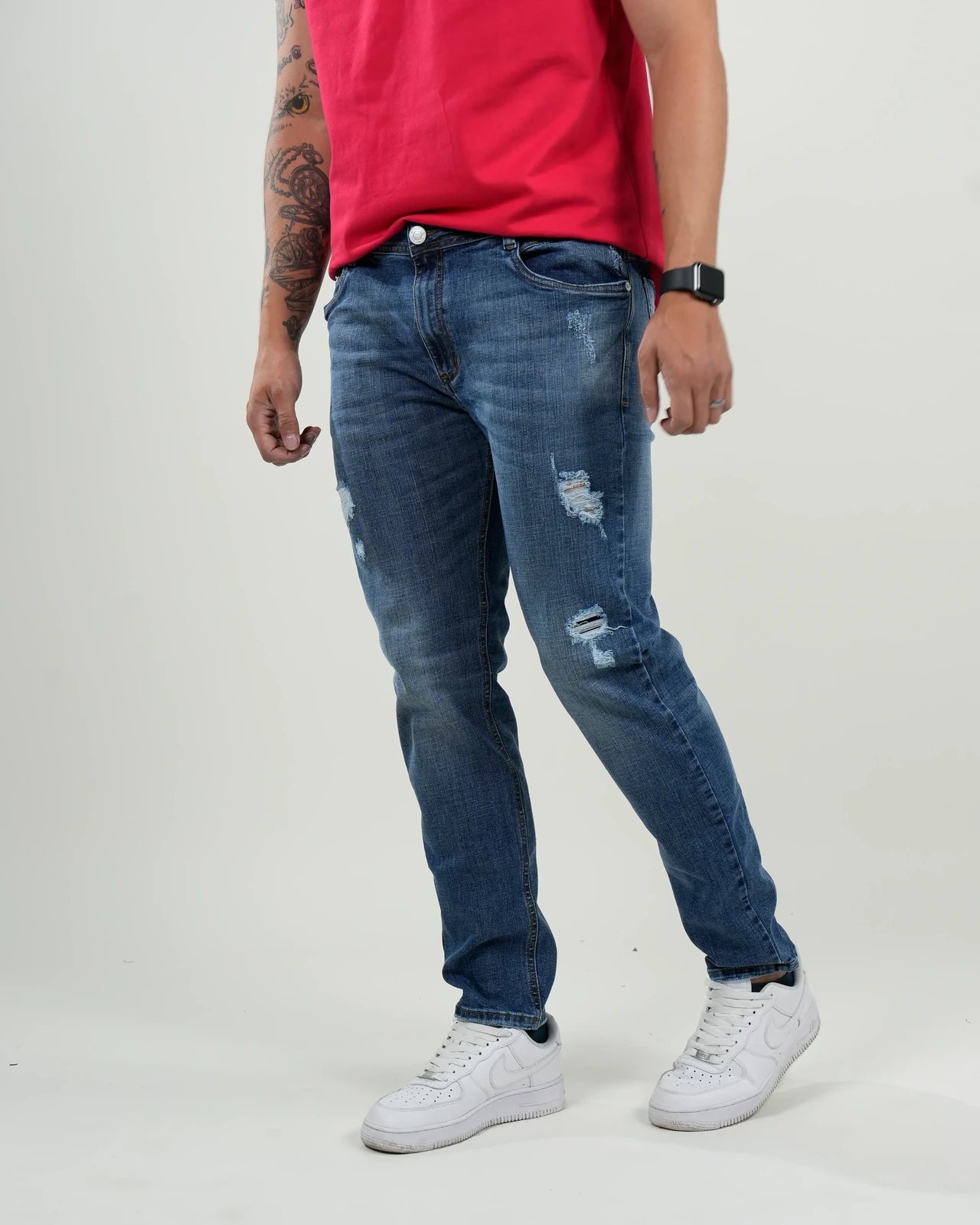 Jeans azul medio con efecto desgastado y rasgados decorativos