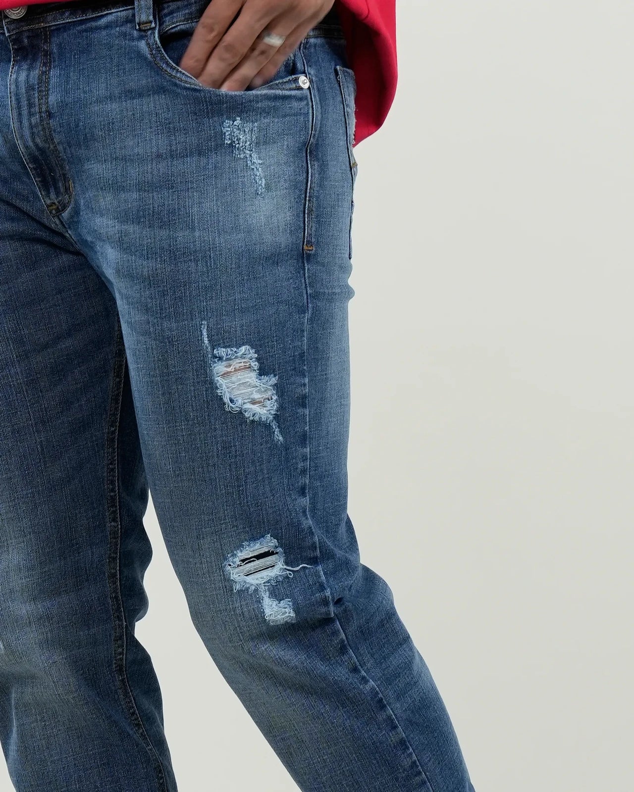 Jeans azul medio con efecto desgastado y rasgados decorativos
