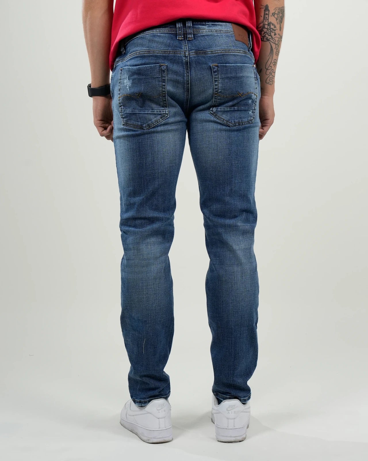 Jeans azul medio con efecto desgastado y rasgados decorativos