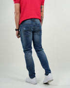 Jeans azul medio con efecto desgastado y rasgados decorativos