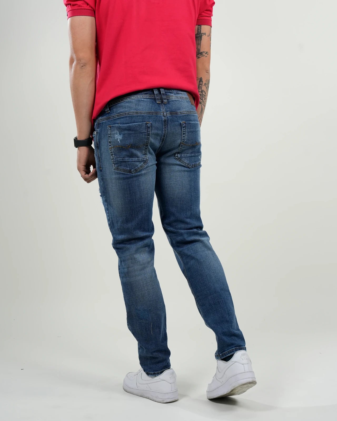 Jeans azul medio con efecto desgastado y rasgados decorativos