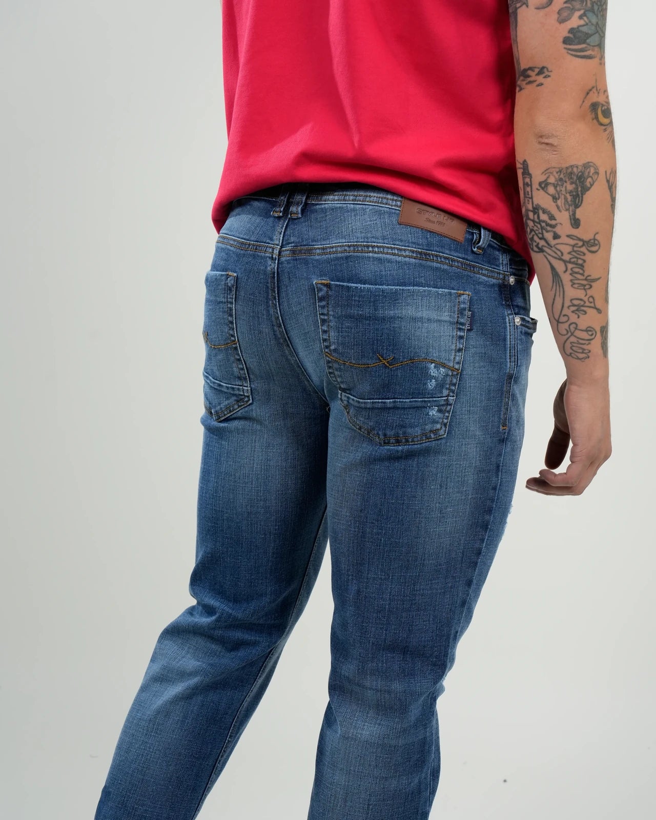Jeans azul medio con efecto desgastado y rasgados decorativos