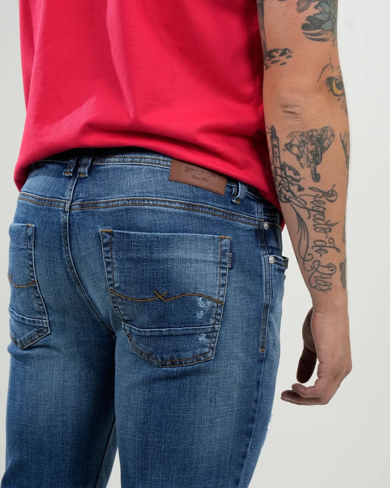 Jeans azul medio con efecto desgastado y rasgados decorativos