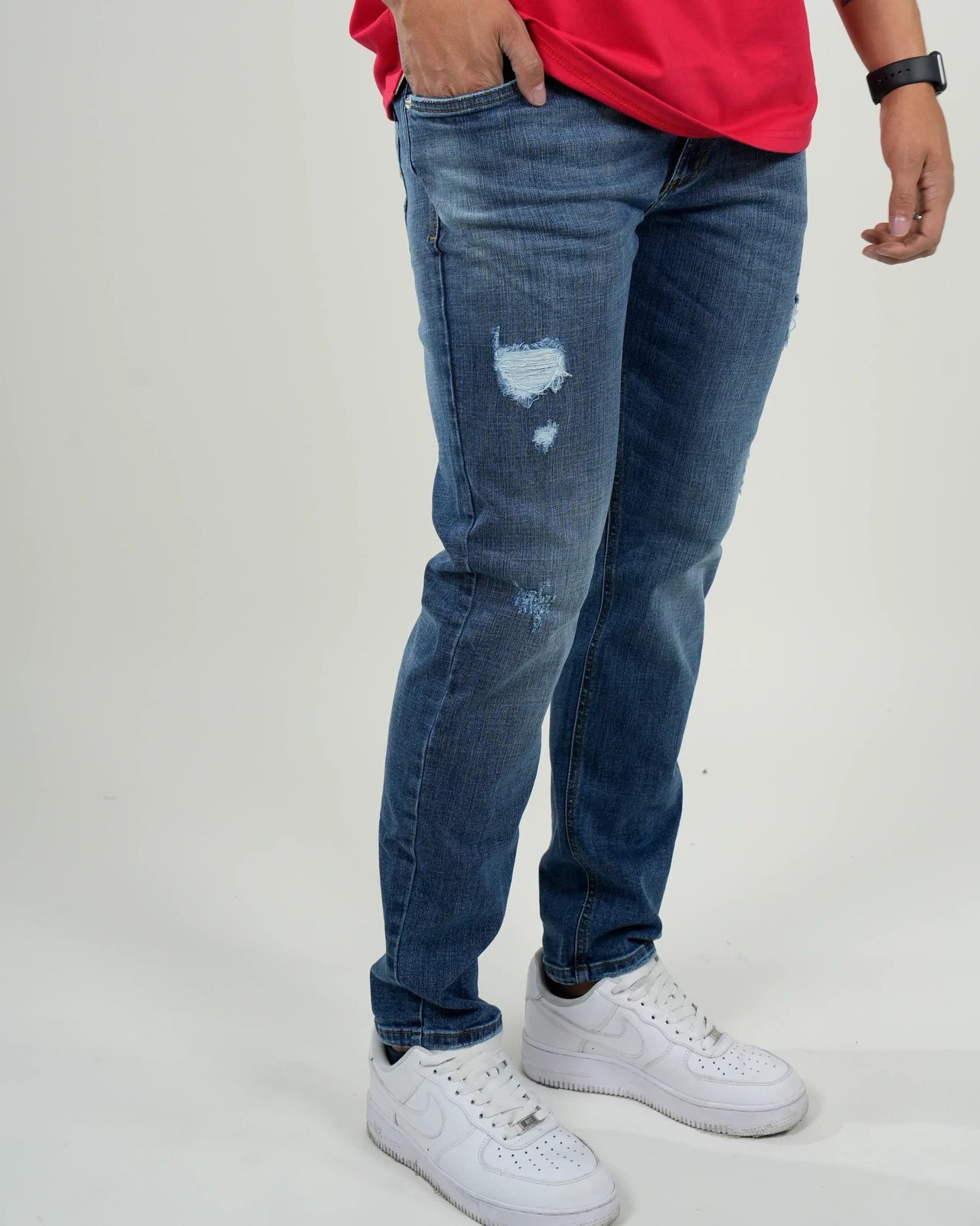 Jeans azul medio con efecto desgastado y rasgados decorativos